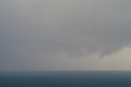Dramatic sky and clouds at stormy day over the sea, Clouds raining over the seaの写真素材