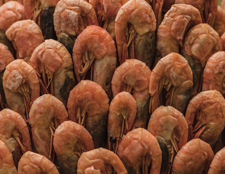 Large appetizing pile of boiled shrimp neatly folded in a basket, close-up