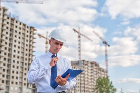 civil engineer in a white helmet on the background of houses under construction.の写真素材