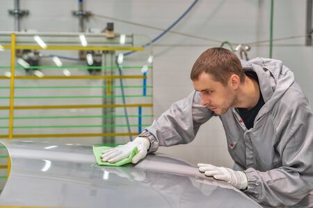 An employee of the paint shop of an automobile plant learns to remove dust with a special wax rag. Production interiors.の写真素材