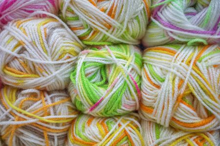 Multicolored wool balls of yarn. Background of colored yarn balls. Embroidery. Knitting. Hobbies and...
