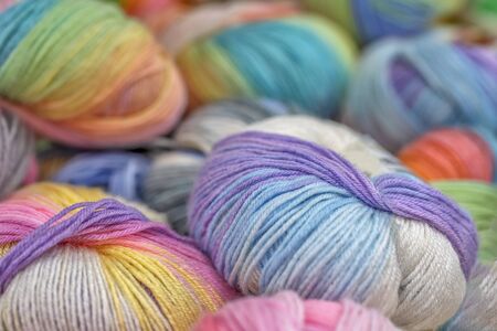 Multicolored wool balls of yarn. Background of colored yarn balls. Embroidery. Knitting. Hobbies and...
