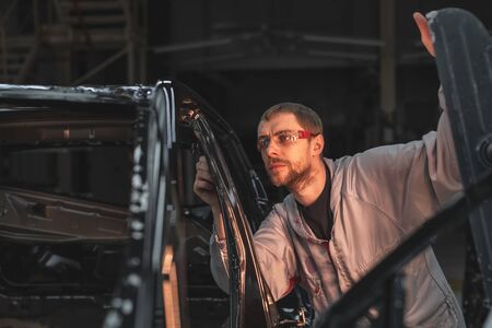 Employee car body painting shop checks the quality of the painted surfaceの写真素材