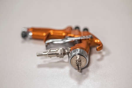 orange professional sprayer on a grey background. Paint shop. Automobile plant.の写真素材
