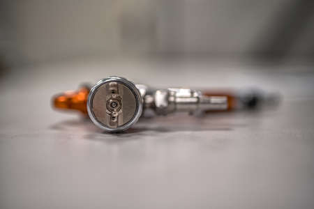 orange professional sprayer on a grey background. Paint shop. Automobile plant.