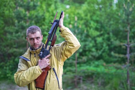Young man shooting with a crossbow in a forest. A man with a crossbow in his hands.