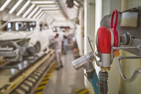pneumatic sander on the background of a car factory production line. working tool.