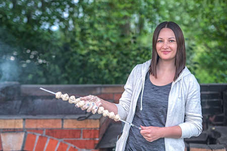A woman prepares mushrooms on the grill. Vegetarianism.の写真素材