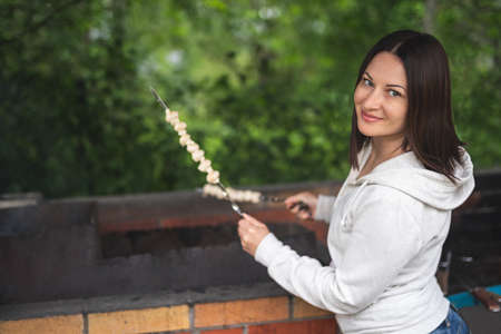 A woman prepares mushrooms on the grill. Vegetarianism.の写真素材