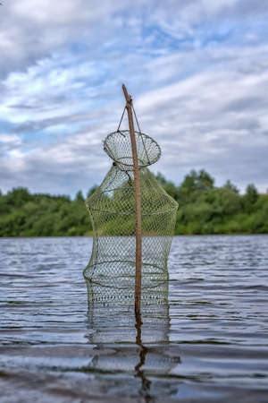 Fishing pond - a fish trap, a device for storing caught fish while fishing. The caught fish is placed alive in the cage and, for the duration of the fishing, is lowered to a depth of 1-2 metersのeditorial素材