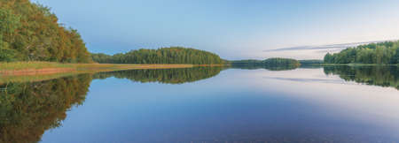 Panoramic image of a forest lake in early autumn, natural lightの写真素材