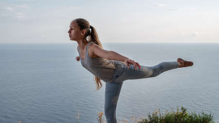 girl doing gymnastics on the background of the sea. Daylight