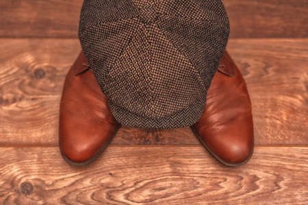 Men's accessories, brown leather shoes, wool cap on a wooden background