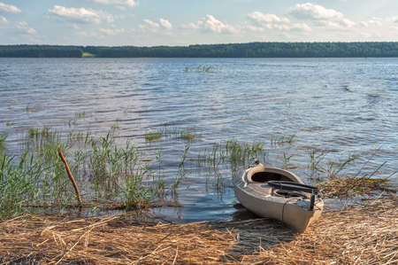 kayak on the sandy shore of the lake on a bright sunny day.