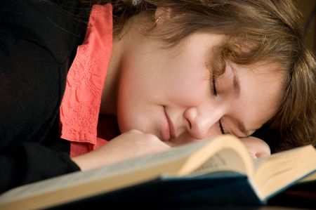 adorable woman student is sleeping on booksの写真素材