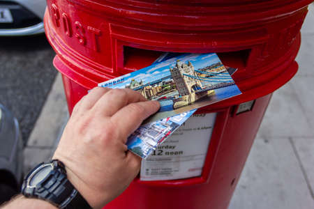 London, UK - 31 July, 2018: Sending postcards via the legendary London's red mailbox.のeditorial素材
