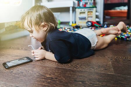 A little boy sitting at a table using a laptop