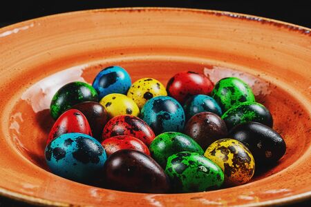 Happy Easter. Traditionally, eggs are painted at Easter. Colorful quail eggs on wood 