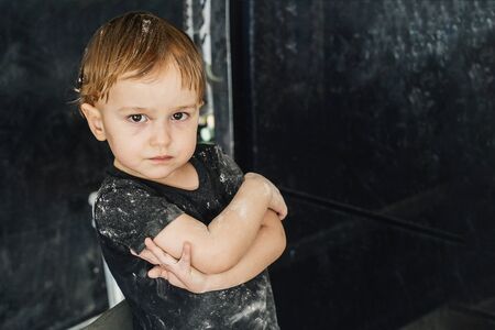 Little offended boy soiled the kitchen flour and himselfの写真素材