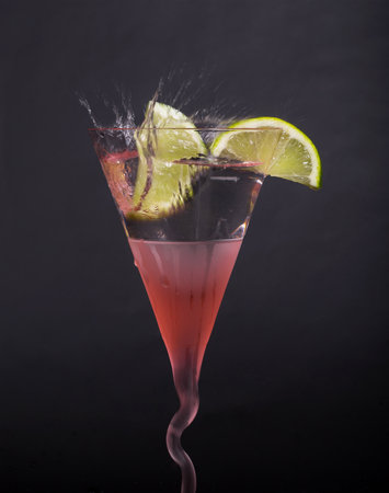 Lemon, lime, splash in martini glass, isolated, splashes on a black background, in red glassの写真素材