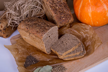 a loaf of bread on the background of cutting boards and other bread and pumpkin,