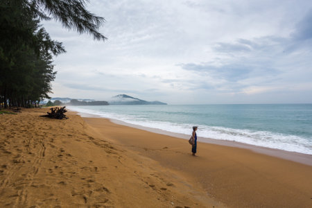 Girl in helmet on yellow sand, shore of Andaman Seaの写真素材