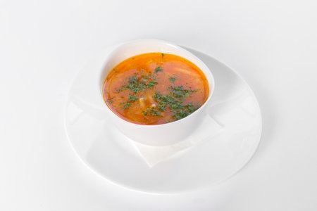 a plate of soup with greens on a white backgroundの写真素材