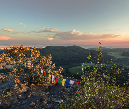 colored flags on top of a mountain at sunset