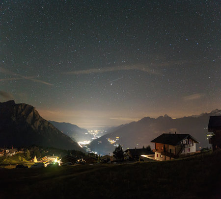 the milky way above the village in the alps, the starry sky in switzerlandの写真素材