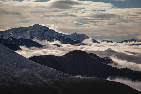 carpet of clouds in the mountains, snow line and mountain peaks