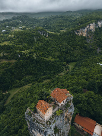 forest covered gorge and house on a rock pillar, cliff house on top, aerial viewの写真素材