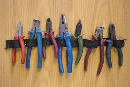 Pliers and wire cutters are hanging on the wall