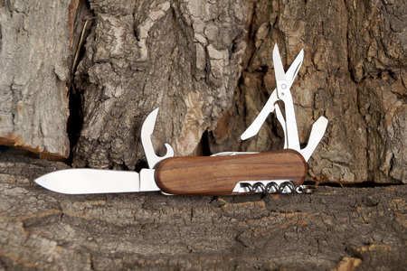 Folding multipurpose knife with the wooden handleの写真素材