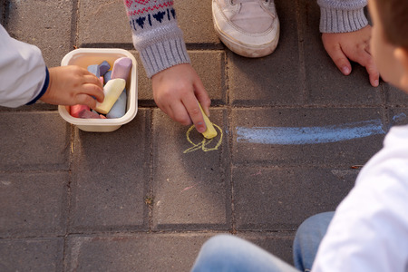 Drawing by crayons on asphalt in city park