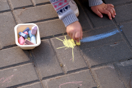 Drawing by crayons on asphalt in city park