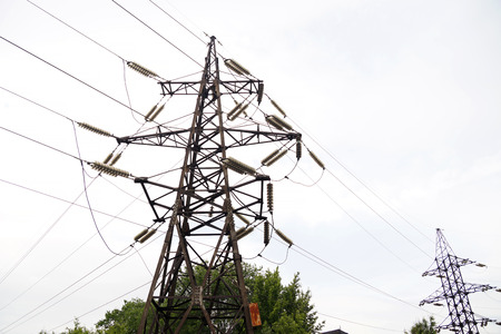 Old rusty mast of power lines on the city streetの写真素材
