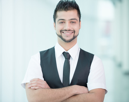 Young Asian Indian businessman standing on office backgroundの写真素材