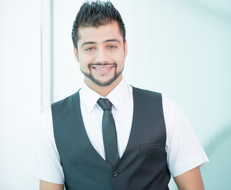 Young Asian Indian businessman standing on office backgroundの写真素材
