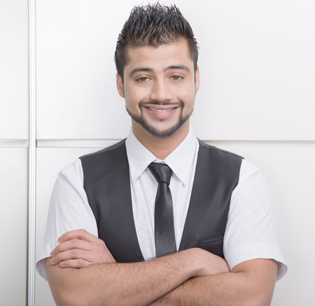 Young Asian Indian businessman standing on office backgroundの写真素材