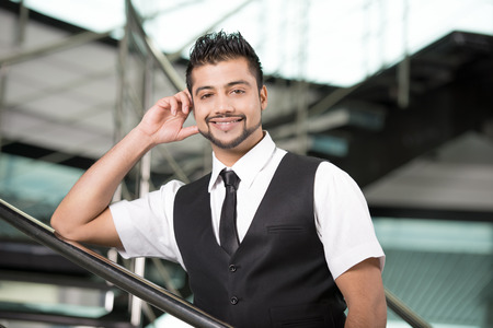 Young Asian Indian businessman standing on office backgroundの写真素材
