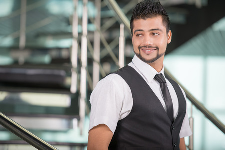 Young Asian Indian businessman standing on office backgroundの写真素材