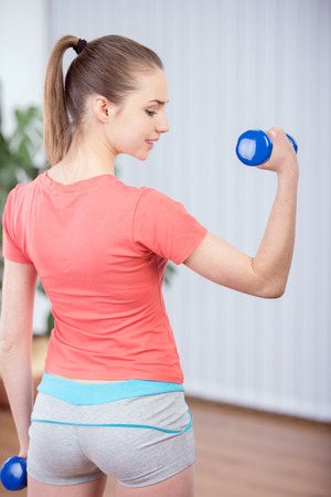 Fitness woman working out with dumbbellsの写真素材