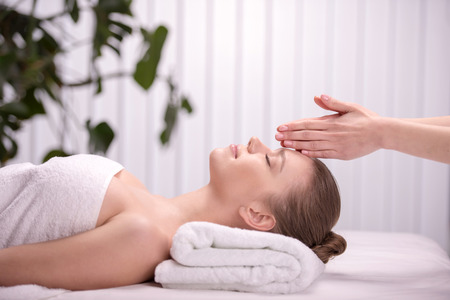 Cheerful naked young woman lying on front receiving messageの写真素材