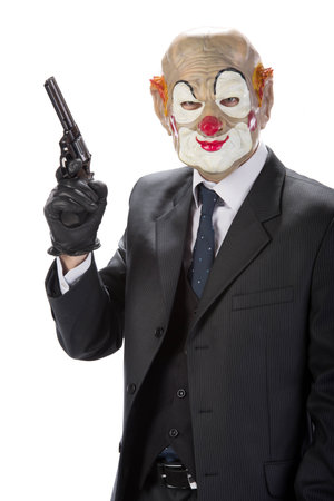 Gangster masked clown with a gun during a robbery isolated on white backgroundの写真素材