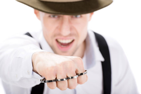 Aggressive young gangster with brass knuckles to fight isolated on white background