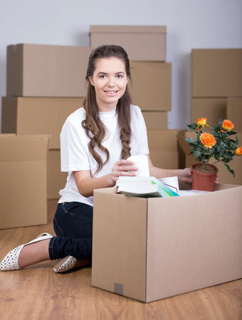 Woman unpacking boxes in living roomの写真素材