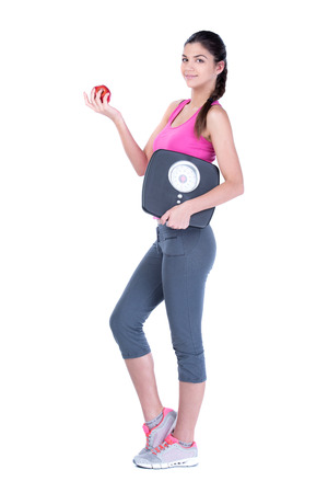 Healthy diet eating woman with scale and apple for weightloss isolated on white の写真素材
