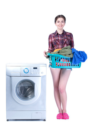 Young beautiful woman doing laundry in the washing machine. Isolated on white の写真素材