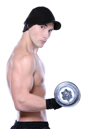 Muscular guy doing exercises with dumbbells over white backgroundの写真素材