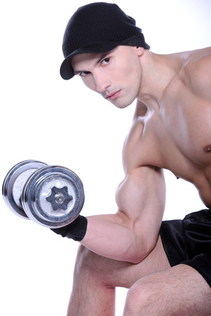Muscular guy doing exercises with dumbbells over white backgroundの写真素材